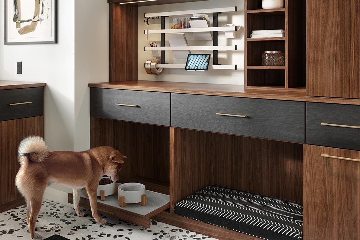 Customized mudroom storage space with pet bed and feeding station designed by California Closets